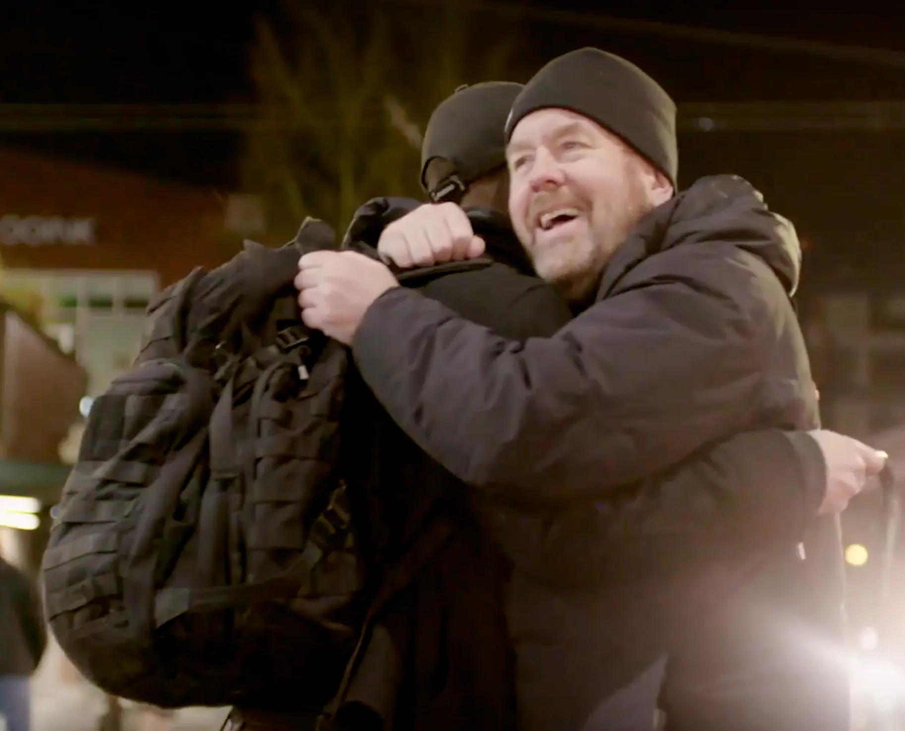 A warm embrace between two people on a city street, from How Are You Tonight